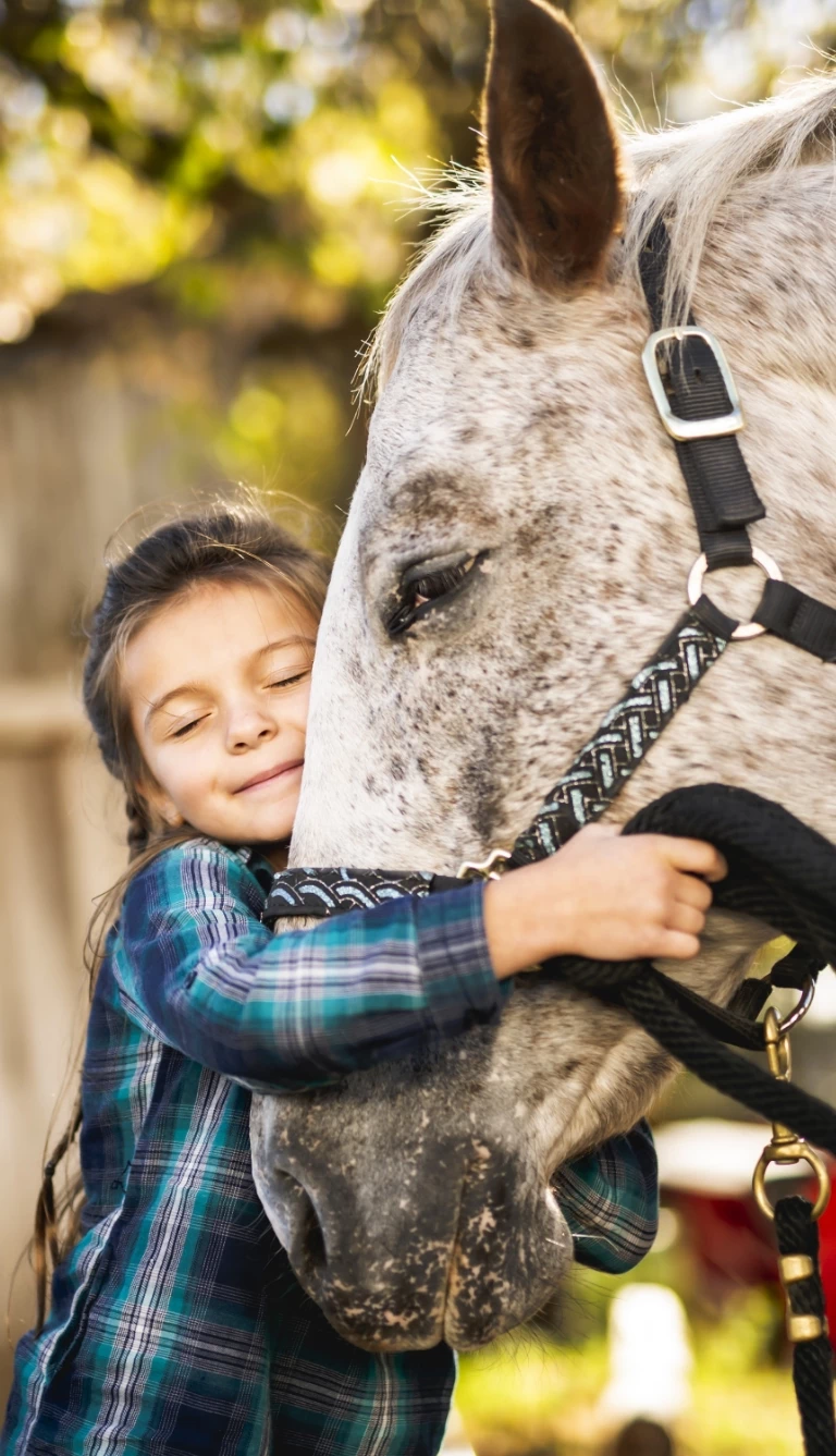 Terapia przytulenie przez chłopca konia